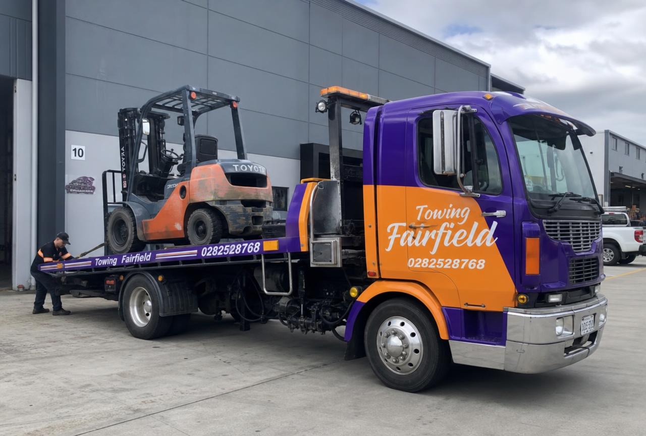 Forklift being loaded onto a Towing Fairfield heavy tilt tray truck